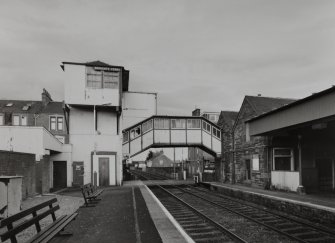 View from west of wooden tower and overbridge (left), rubble-built station offices (right), and part of platform canopy (far right)