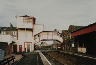 View from west of wooden tower and overbridge (left), rubble-built station offices (right), and part of platform canopy (far right)