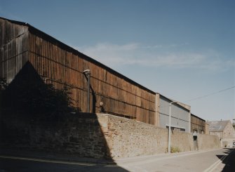 View from SSW of steel-framed, corrugated-sheet-metal clad raw jute warehouse, detached from main block of works, and situated opposite on NW side of Douglas Street