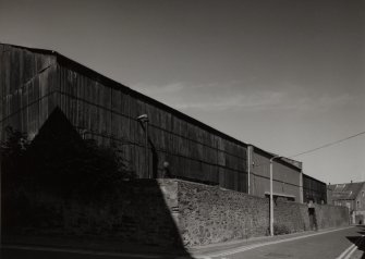 View from SSW of steel-framed, corrugated-sheet-metal clad raw jute warehouse, detached from main block of works, and situated opposite on NW side of Douglas Street