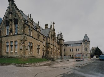 View of south east face of main block with modern extension behind from south south west (after fire)