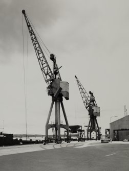 King George V Wharf, view from NE showing Stothert and Pitt electric powered 7 ton travelling keyside cranes built in 1971. Dock crane nos. 49 and 50
Photographed 28 July 1987