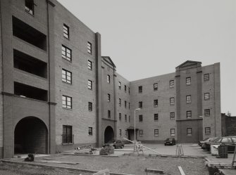 General view from NW of portion of warerhouse comprising 31-5 Trades Lane, reduced in depth, and convered to Scottish Housing Association dwellings (completed in 1995)