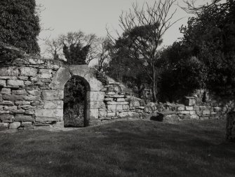 Exterior view of S wall of church, showing doorway at W end.