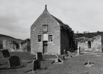 View of church from SE, showing gable-end of S burial-aisle with armorial panel and roof finial.