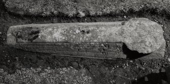 Medieval coped grave-cover in burial-ground, immediately S of church.