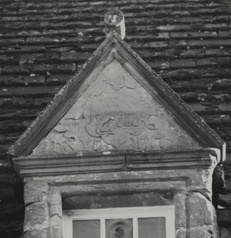 Detail of inscribed pediment of dormer window of old house.
