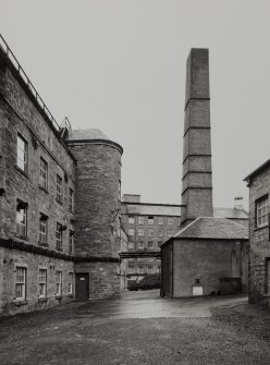 View of Mid Mill, Bell Mill & boiler house with chimney stack from South-East.