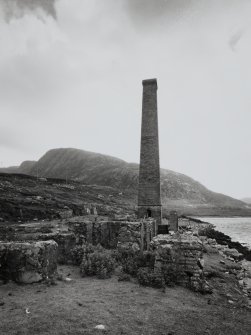 View from NNW of suviving boiler house chimney, with concrete bases of former whale oil tanks in foreground.