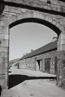 View from SW through gateway to W side of castle, showing associated terrace of cartsheds and dwellings
