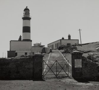 View from N of main gate to inner compound, showing plaque (right), and lighthouse buildings in background