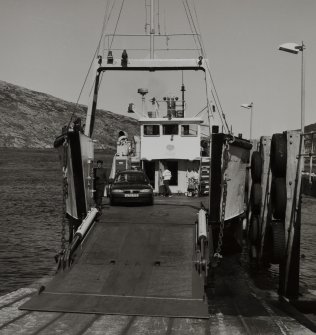 View from WSW of ramp and Isle of Rhum ferry moored at the Scalpay side, prior to moving into position to receive cars and foot passengers