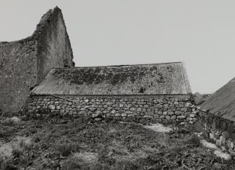 Single storey building to East of ruinous castle, view from South.