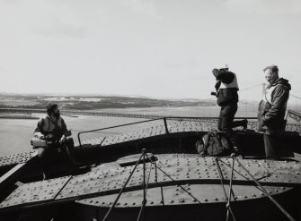 Angus Lamb and Miles Oglethorpe (RCAHMS) and a Forth Bridge Inspector on top of the Fife erection with the Forth Road Bridge in the background.