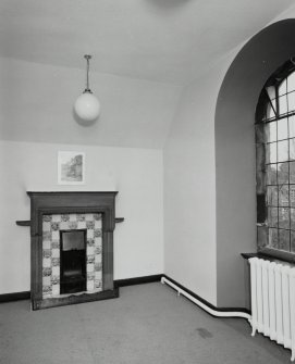 Interior, view of top floor South East room in side wing showing original stone fireplace with tiled insert