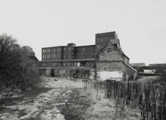 View from NNW of N side of W end of former floor maltings block, which contained barley silos.  The red saladin maltings building can be seen in the background