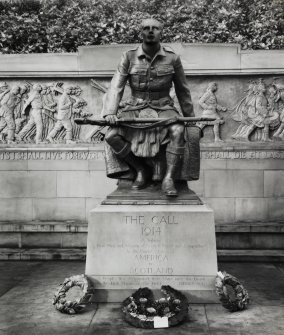 View of memorial with wreaths placed at the base of the statue of the soldier.