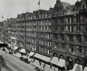 Modern print from an original negative. General view of Nos 47 - 59 Princes Street showing awnings on shop fronts and cars parked outside.