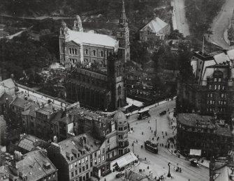 Oblique aerial view from the northwest of the West End of Princes Street showing St John's Church, St Cuthbert's Church, Maules Store (now Frasers) and part of the Caledonian Hotel.