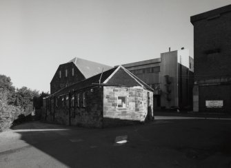 View from SW of gatehouse and offices (foreground), former maltings block (background centre) with new steel-clad block for Saladin boxes, and new whisky bond (right)