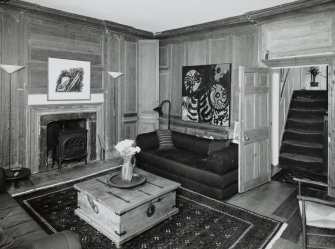 Interior. Second floor. Drawing room showing fireplace and panelling with view to staircase