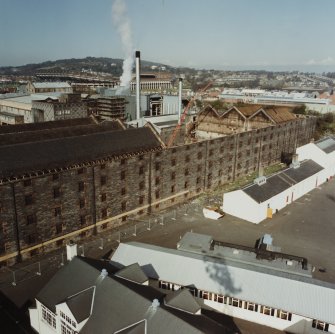 Elevated view from south east (on floodlight tower of Tynecastle Stadium) of range containing Duty Free Warehouses Nos. 5, 6 and 7 (6 roofless), and in background, Still House.