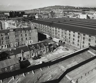 Elevated view from east south east (on SW floodlight tower of Tynecastle Stadium) of Duty Free Warehouses Nos. 3 and 4, with neighbouring Blandfield Chemical Works and Murrayfield Stadium (being re-built) in the background