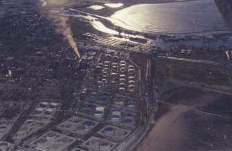 Oblique aerial view centred on the oil refinery, taken from the SE.