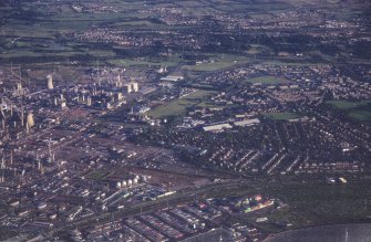 Oblique aerial view centred on the oil refinery and hangers, taken from the NW.