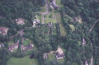 Oblique aerial view centred on the remains of the country house, taken from the WNW.