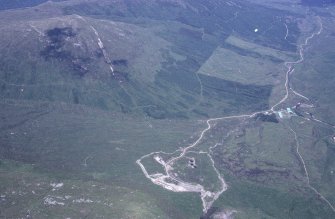 Oblique aerial view centred on the mine and buildings with farmstead adjacent, taken from the SW.