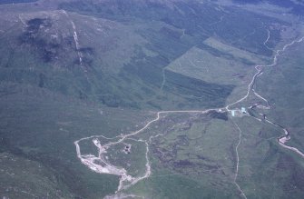 Oblique aerial view centred on the mine and buildings with farmstead adjacent, taken from the SW.