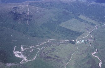 Oblique aerial view centred on the mine and buildings with farmstead adjacent, taken from the SW.