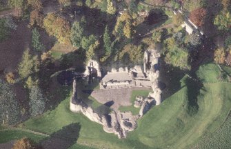 Oblique aerial view of Kildrummy Castle centred on the remains of the castle, taken from the SE.