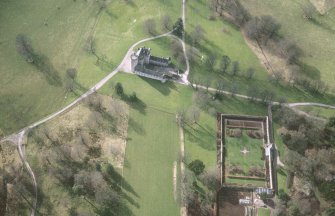 Oblique aerial view of the tower-house with walled garden adjacent, taken from the ENE.