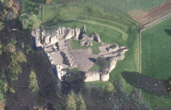 Oblique aerial view of Kildrummy Castle centred on the remains of the castle, taken from the W.
