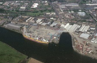 Oblique aerial view of Clydebank centred on John Brown's Shipyard and crane, taken from the SW.