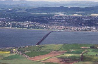 Oblique aerial view looking across River Tay and railway bridge towards the City of Dundee and Grampian mountains, taken from the ESE.