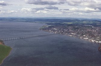 Oblique aerial view looking across River Tay, road and railway bridges towards the City of Dundee and Grampian mountains, taken from the NE.