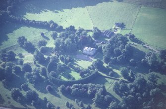 Oblique aerial view centred on the country house with stables and farmsteading adjacent, taken from the ESE.