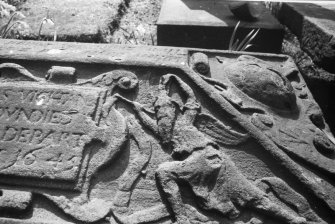 Detail of coped stone 1645 with figures of youth, torch,hourglass.  the Howff burial ground, Dundee,