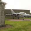 View.  Gate guard  Tornado F2 for technical site main gate with memorial to Norwegian airman of World War Two from NE