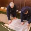 Interior. Mr J Borland and Mr I Parker making a rubbing of a Pictish cross slab