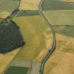 Oblique aerial view centred on the cropmarks of the fort, taken from the WNW.