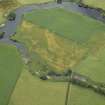 Oblique aerial view centred on the cropmarks of the settlement with the bridge adjacent, taken from the E.