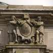 Detail of statues above entrance on NW face, youths supporting the City of Edinburgh Arms