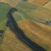 Oblique aerial view centred on the cropmarks of the fort, taken from the NW.