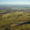 General oblique aerial view centred on the remains of the farmstead, rig, enclosure, sheephouse and sheepfolds with Edinburgh in the distance, taken from the SE.