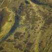 Oblique aerial view centred on the remains of the long cairn, taken from the WNW.