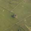 Oblique aerial view centred on the remains of the church and burial ground, taken from the W.